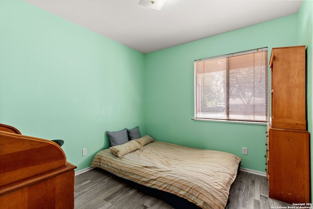 bedroom with dark hardwood / wood-style flooring