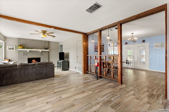 living room with light wood-type flooring, french doors, ceiling fan with notable chandelier, and beamed ceiling