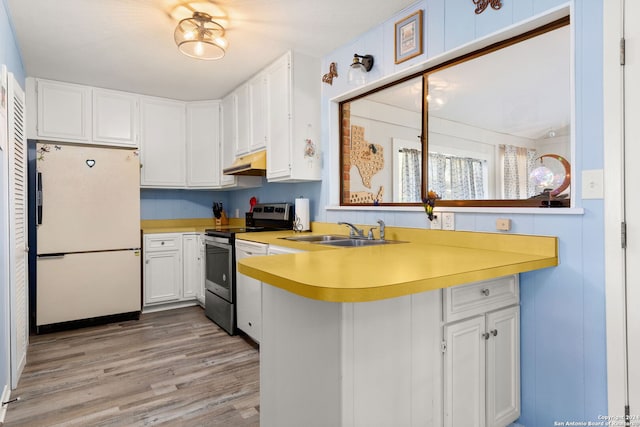 kitchen with white cabinets, white refrigerator, electric stove, sink, and light wood-type flooring