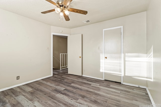 unfurnished bedroom featuring a textured ceiling, hardwood / wood-style flooring, and ceiling fan