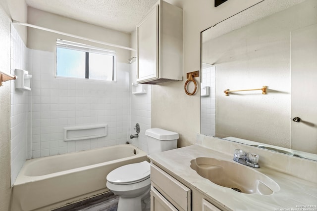 full bathroom with vanity, a textured ceiling, tiled shower / bath combo, hardwood / wood-style flooring, and toilet