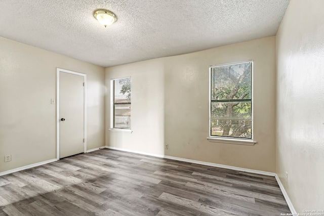 unfurnished room featuring a textured ceiling and hardwood / wood-style flooring