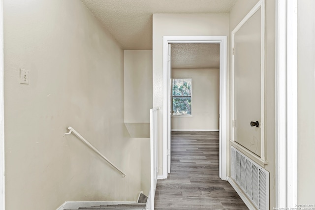 hallway featuring a textured ceiling and light hardwood / wood-style flooring