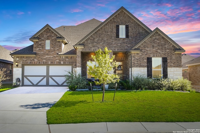 craftsman inspired home with a garage and a yard