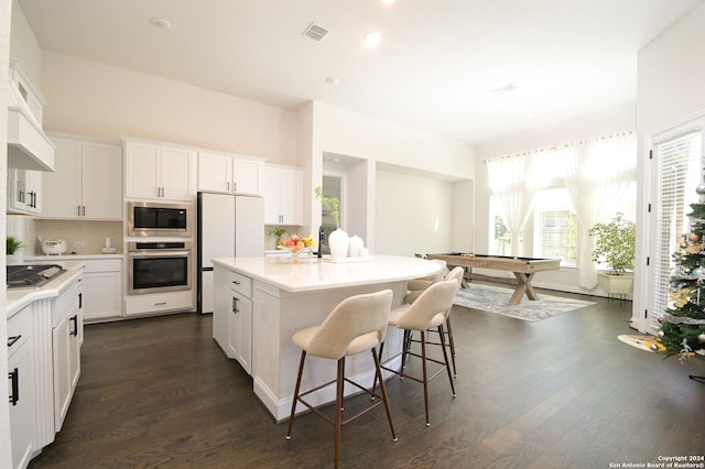 kitchen with white cabinets, a kitchen island, dark hardwood / wood-style flooring, and stainless steel appliances