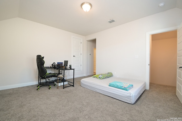 bedroom with light colored carpet and vaulted ceiling