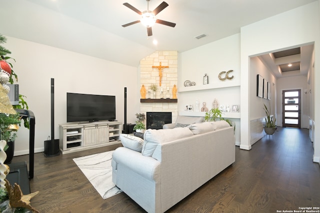 living room featuring a stone fireplace, ceiling fan, dark wood-type flooring, and lofted ceiling