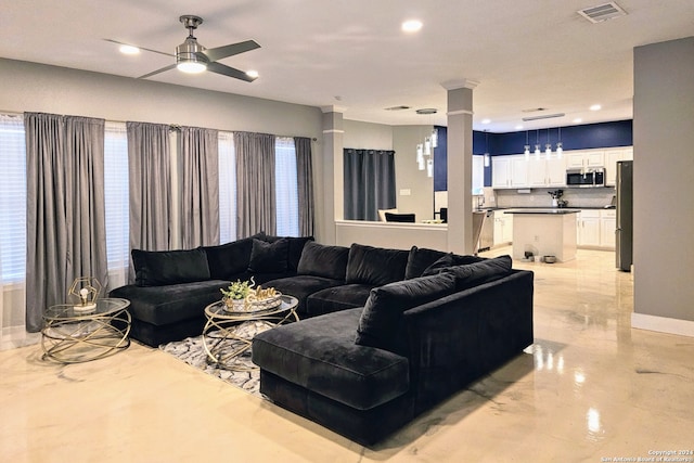 living room featuring ceiling fan and a wealth of natural light