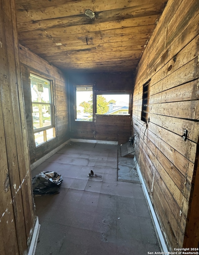 unfurnished room with wood walls and wood ceiling