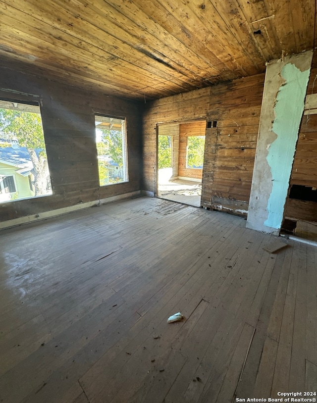 unfurnished room with hardwood / wood-style floors, wooden ceiling, and wood walls