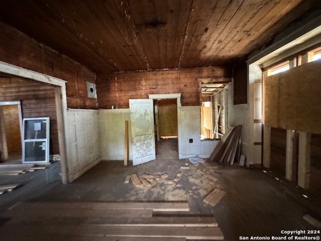 misc room featuring wooden ceiling and wood walls