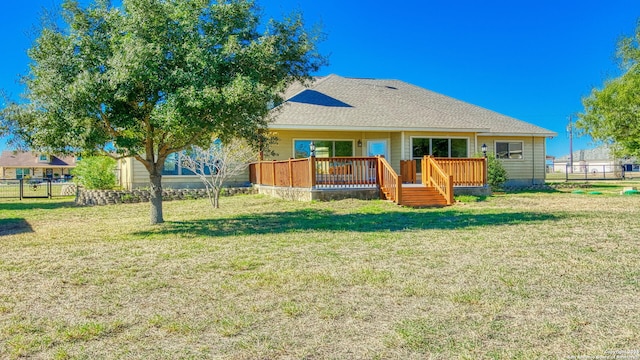 rear view of house featuring a wooden deck and a lawn