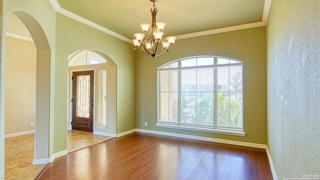 entryway with ornamental molding, light hardwood / wood-style floors, and a notable chandelier