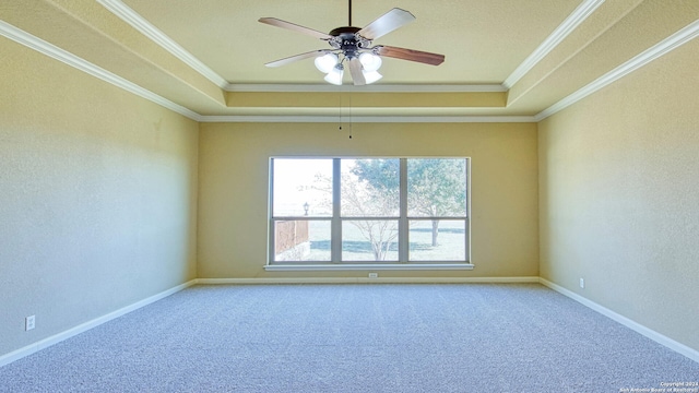 carpeted empty room featuring a raised ceiling, ceiling fan, and ornamental molding