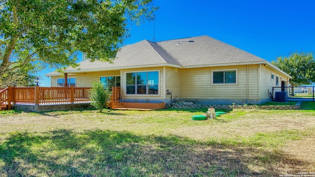 rear view of property featuring a lawn, central air condition unit, and a deck