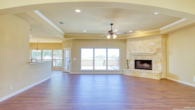 unfurnished living room featuring hardwood / wood-style flooring, ceiling fan, a healthy amount of sunlight, and a fireplace