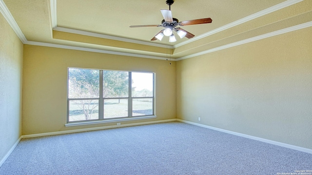 carpeted empty room featuring a tray ceiling, ceiling fan, and crown molding