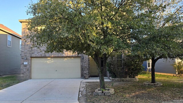 9019 Mimosa Mnr, San Antonio, TX 78245 - obstructed view of property with concrete driveway and stone siding