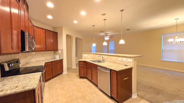 kitchen featuring sink, decorative light fixtures, decorative backsplash, ceiling fan with notable chandelier, and appliances with stainless steel finishes