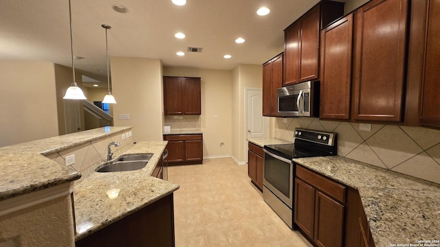 9019 Mimosa Mnr, San Antonio, TX 78245 - kitchen featuring appliances with stainless steel finishes, backsplash, recessed lighting, hanging light fixtures, and light stone counters