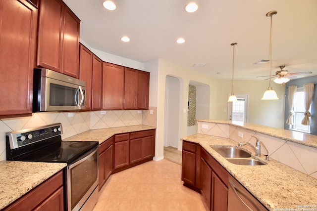 9019 Mimosa Mnr, San Antonio, TX 78245 - kitchen featuring stainless steel appliances, arched walkways, recessed lighting, decorative backsplash, and light stone counters