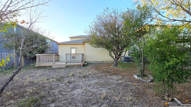 rear view of property with cooling unit and a wooden deck