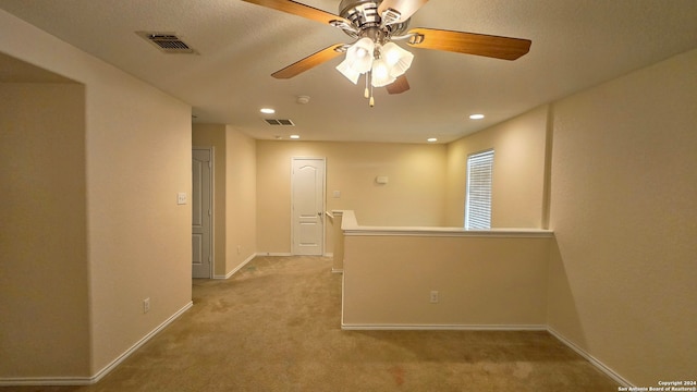 unfurnished room with light carpet and ceiling fan