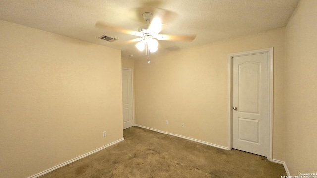 unfurnished room with carpet flooring, ceiling fan, and a textured ceiling