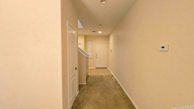 hall with light colored carpet