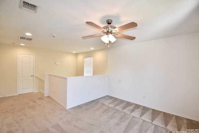 carpeted spare room with ceiling fan