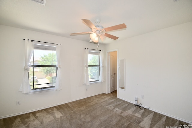 carpeted spare room with ceiling fan