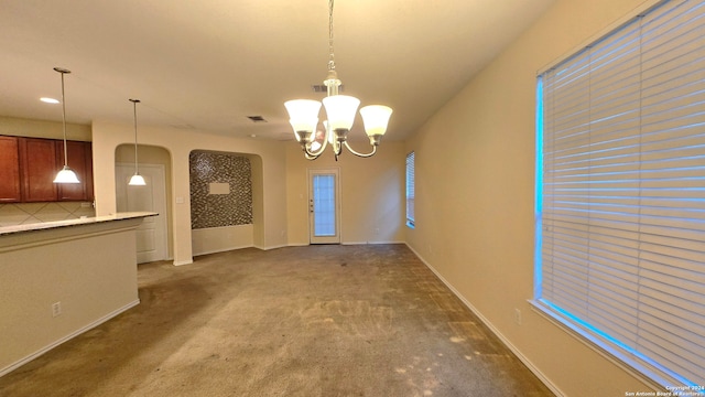 interior space featuring a chandelier and dark carpet