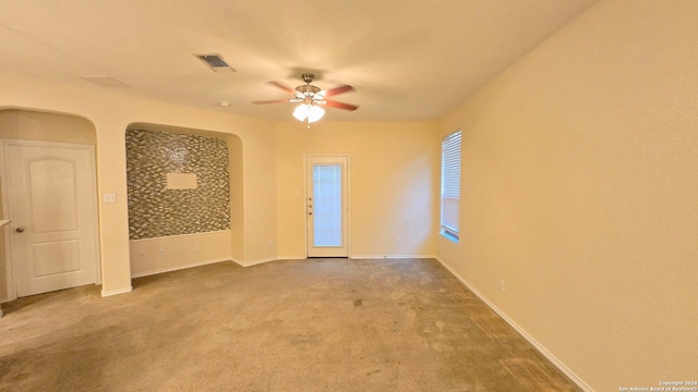 carpeted spare room featuring ceiling fan