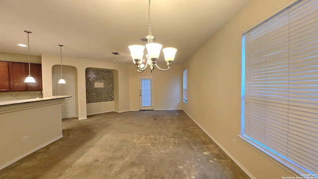 9019 Mimosa Mnr, San Antonio, TX 78245 - unfurnished dining area with arched walkways, dark carpet, and a chandelier
