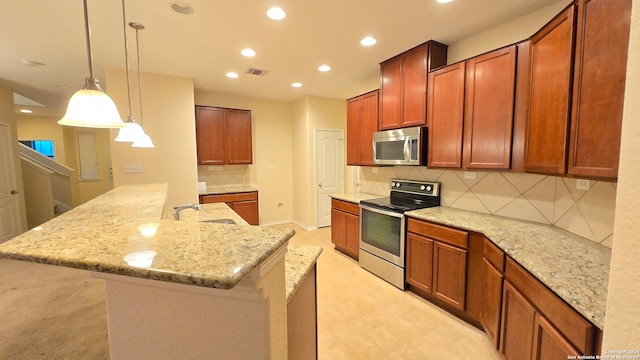 kitchen with decorative light fixtures, decorative backsplash, light stone countertops, and appliances with stainless steel finishes