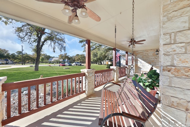 wooden deck featuring ceiling fan, a yard, and covered porch