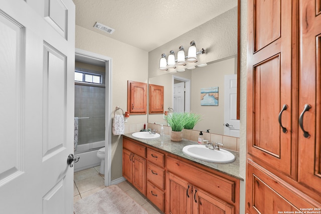 full bathroom featuring vanity, tiled shower / bath, tile patterned flooring, toilet, and a textured ceiling