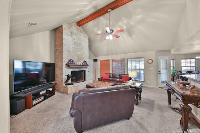 carpeted living room with beamed ceiling, plenty of natural light, a fireplace, and high vaulted ceiling