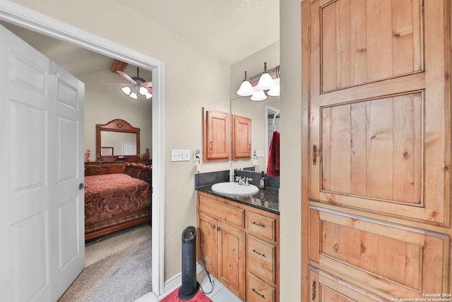 bathroom with ceiling fan, vanity, and vaulted ceiling