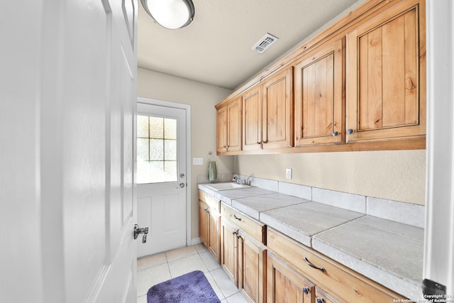 laundry area with light tile patterned floors and sink