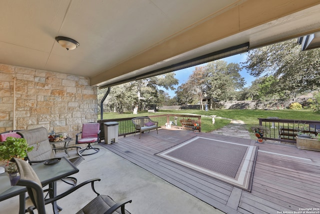 wooden deck featuring a lawn