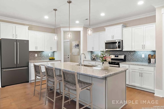 2830 Sueno Pt, San Antonio, TX 78245 - kitchen featuring appliances with stainless steel finishes, ornamental molding, decorative backsplash, white cabinets, and light wood-type flooring