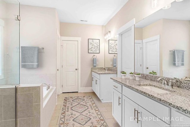 2830 Sueno Pt, San Antonio, TX 78245 - full bathroom with a bath, two vanities, tile patterned floors, and a walk in shower