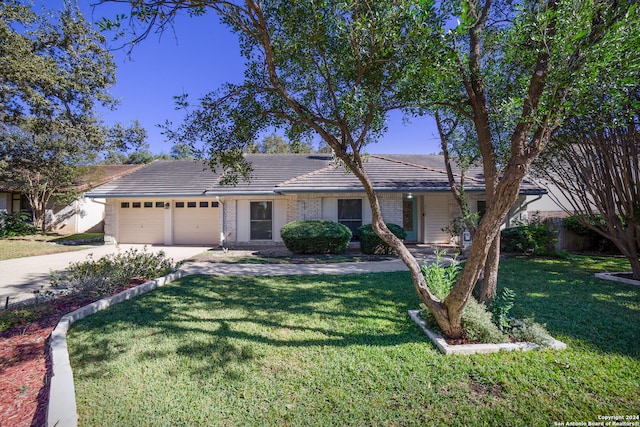 ranch-style house featuring a front yard and a garage