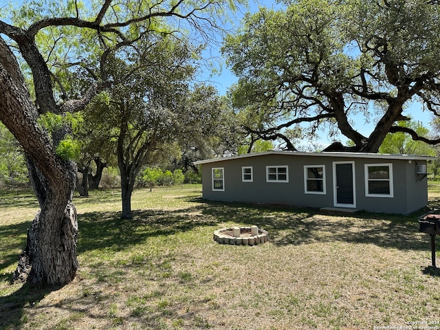 view of front of house featuring a front lawn and a fire pit