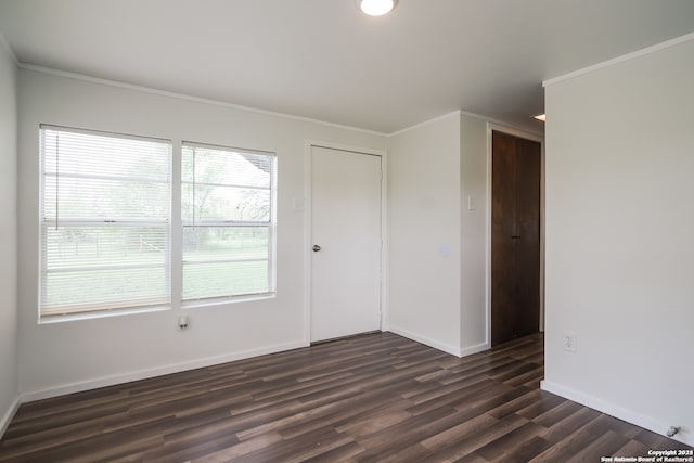 spare room with dark hardwood / wood-style flooring and crown molding