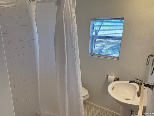 bathroom featuring tile patterned flooring, a shower with shower curtain, toilet, and sink