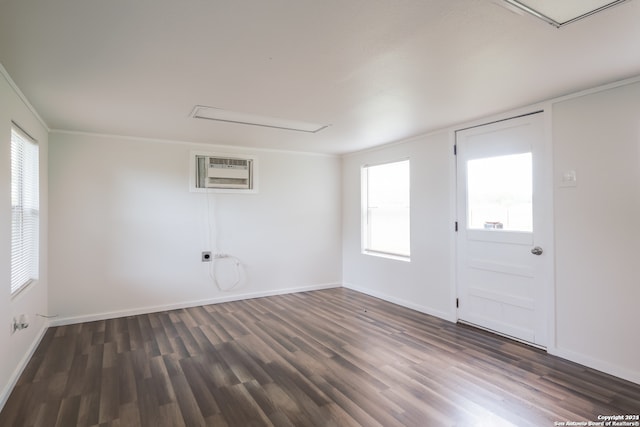 unfurnished room with a wall mounted air conditioner, dark hardwood / wood-style floors, a healthy amount of sunlight, and crown molding