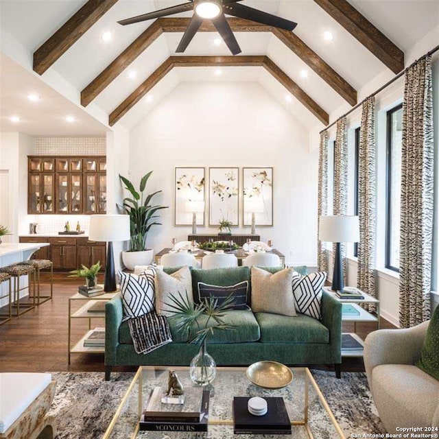 living room with beamed ceiling, ceiling fan, wood-type flooring, and high vaulted ceiling