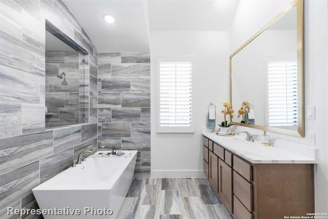 bathroom with a tub, a healthy amount of sunlight, and vanity